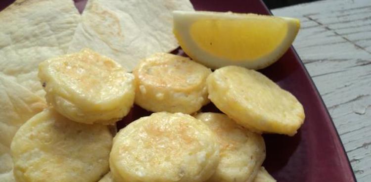 Fried Egyptian Cheese known as Gebna Makleyah with a lemon wedge and flat bread