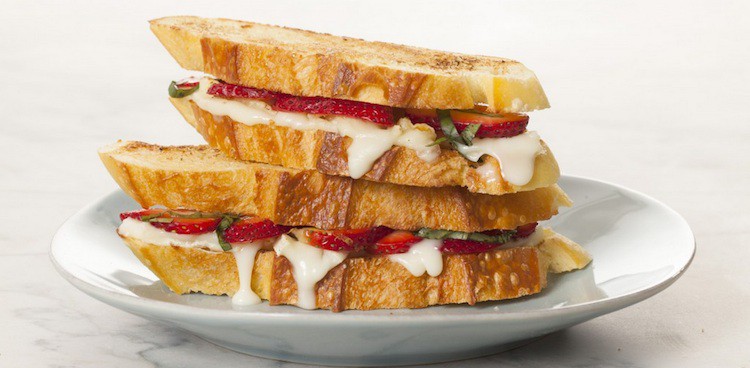 Stacked grilled cheese sandwiches with melted goat cheese, sliced strawberries, and chiffonade basil