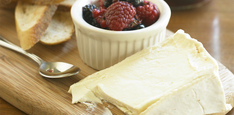 balsamic berry accompaniment next to a wedge of triple creme cheese