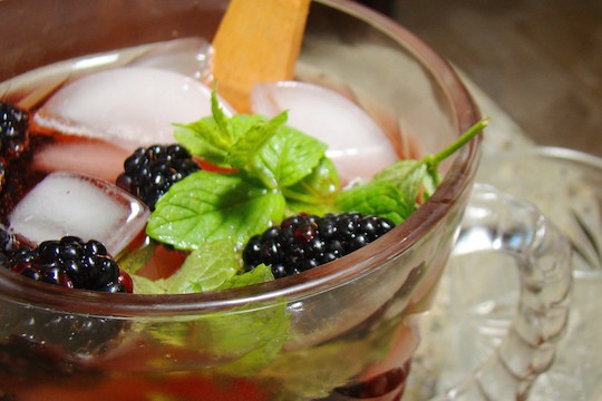 drink in clear glass with ice, mint, and blackberries