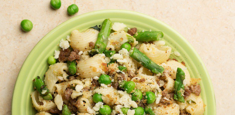 Conchiglie pasta with ground pork, English peas, asparagus, and crumbled hard cheese