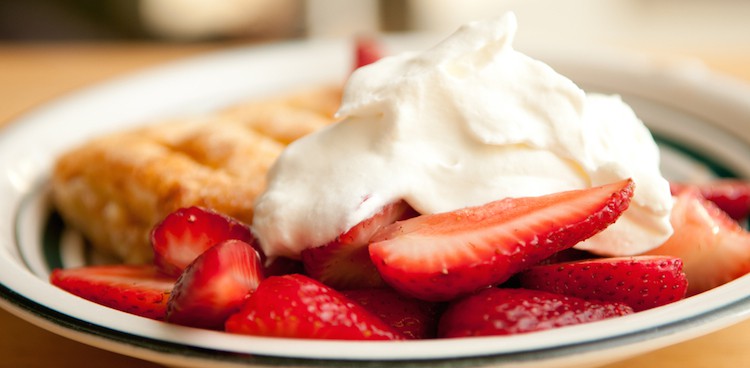 sliced strawberries and mascarpone alongside a fluffy slice of shortcake