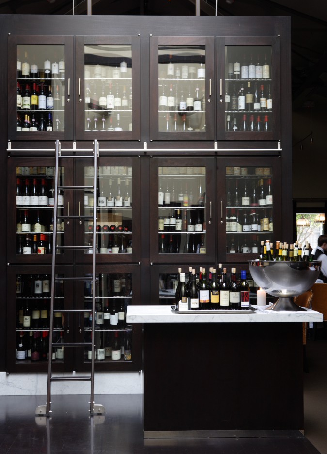 Hundreds of bottles of wine inside glass cabinets.