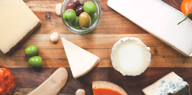 cheese plate with mimolette, bucheron, brie, and olives