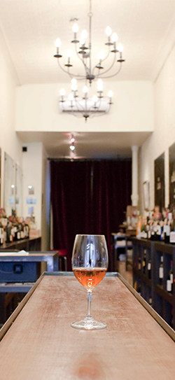 A glass of sherry sits on a wooden bar counter