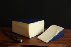 Creama Kasa cheese on wood with slice cut from it