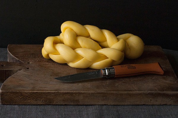 Braided Caciocavera cheese on board with pairing knife