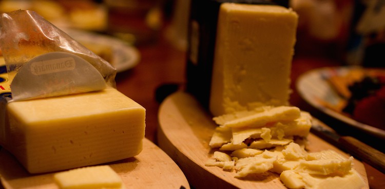 Two block cheddar cheeses being served for a party