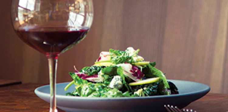 wilted spinach salad with glass of red wine