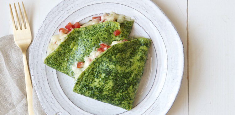 vibrant bright green kale crepes wraped around melted cheddar cheese and tomato salsa