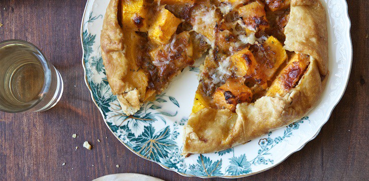Rustic winter galette tart with squash and onions on china plate