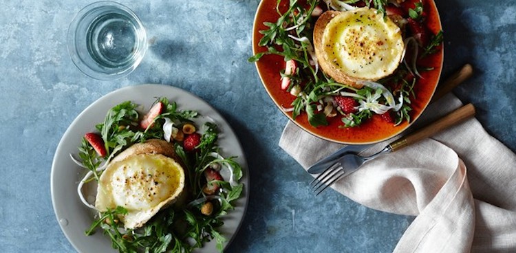 Broiled goat cheese toasts sit atop two brightly color spring salads with arugula and strawberries