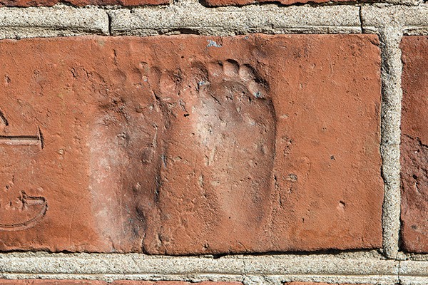 Footsteps on a brick on the side of the building that now produces Almnäs Tegel cheese