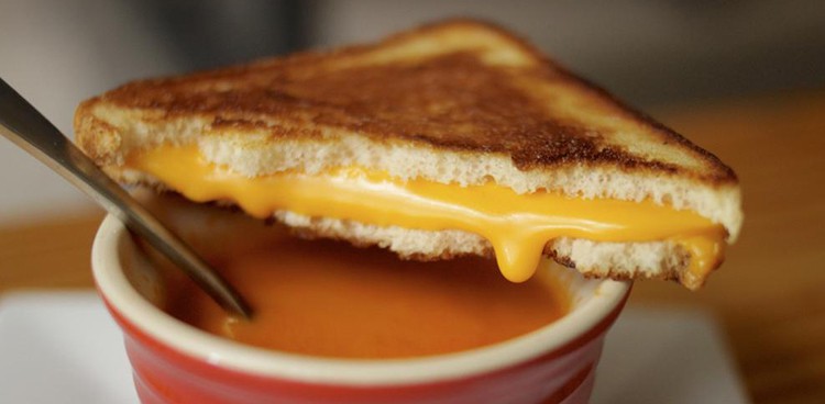 Grilled cheese over mug of tomato soup