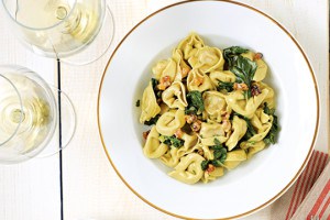 A bowl of tortellini with Crème Fraîche, Swiss Chard, and Toasted Walnuts