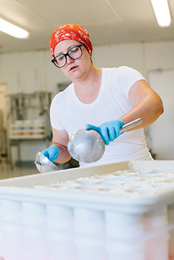 Rebecca Williams ladles curds into molds.