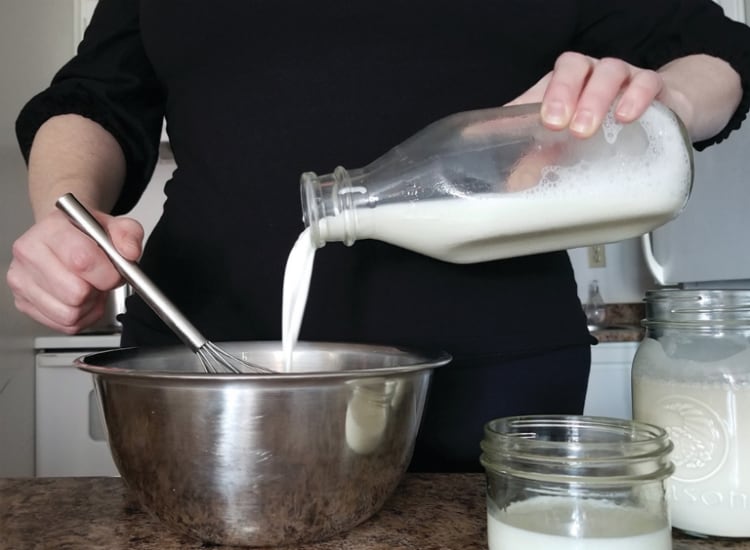 pouring milk into a mixing bowl