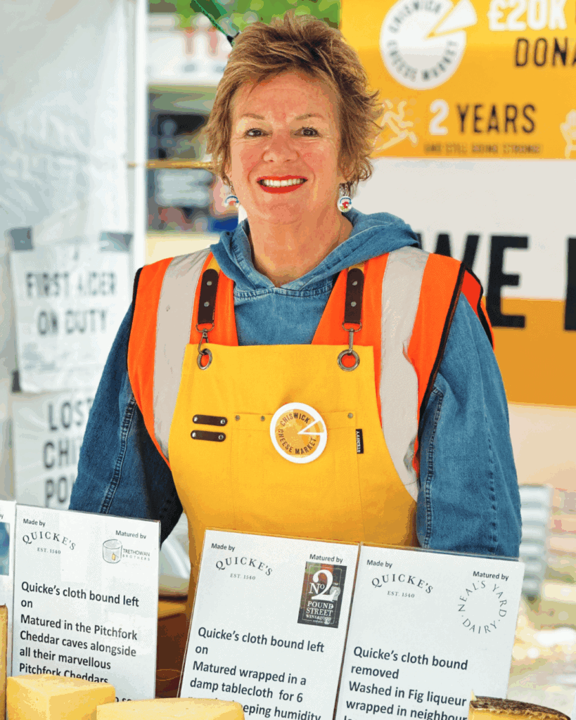 Lucy Cufflin, a founder of the Chiswick Cheese Market in London, smiles at one of the market's stalls. The market started in 2021 as an outdoor means of selling cheese during the pandemic. Photo courtesy of Lucy Cufflin.